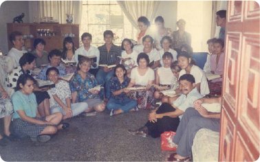 Hermanos de la comunidad reunidos en una casa leyendo la Biblia